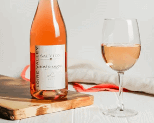A bottle of rose wine and a glass of wine.