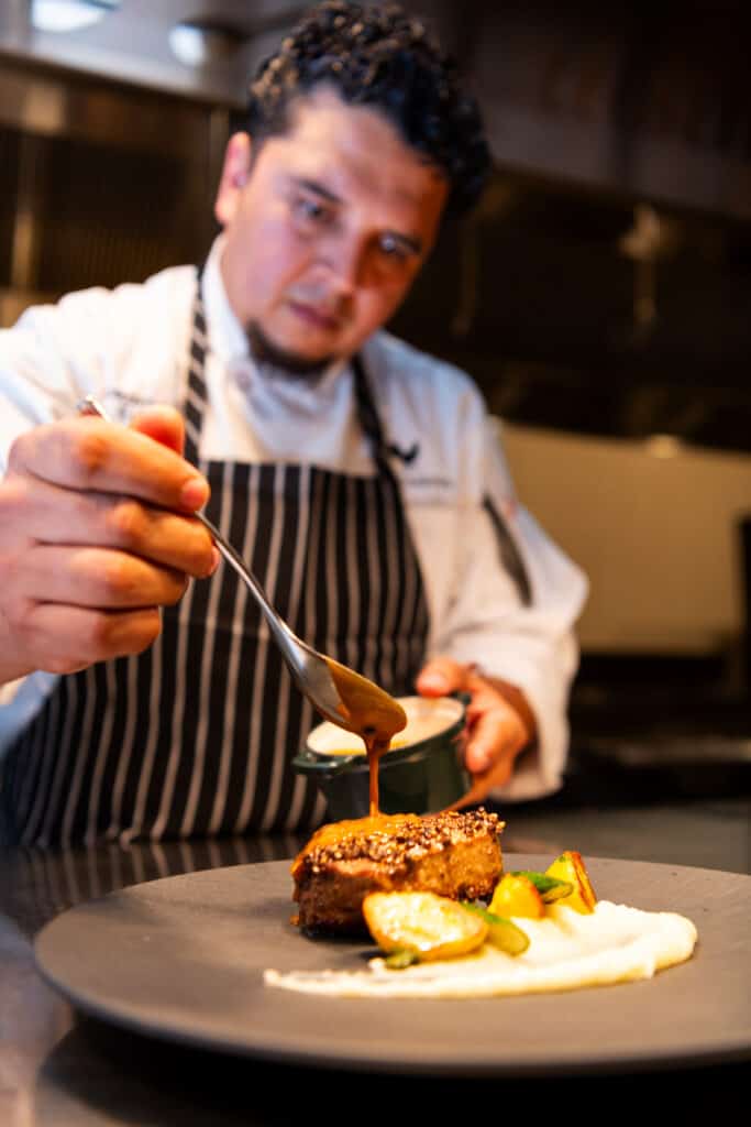 Chef preparing a dish at Artisans Houston Chef preparing a dish at Artisans Houston